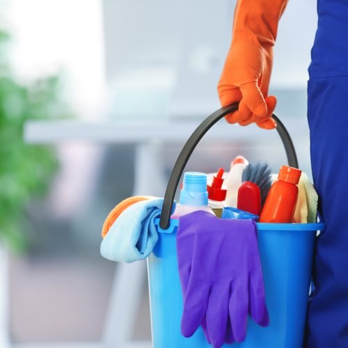 holding cleaning products and tools on bucket, close up